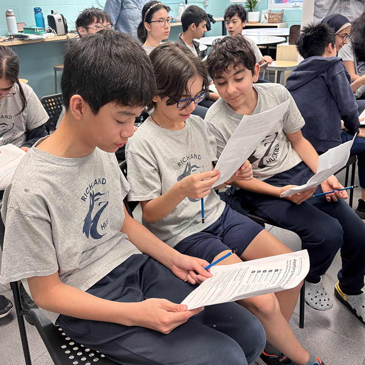 Grade 7 students listen to a guest speaker in the classroom.